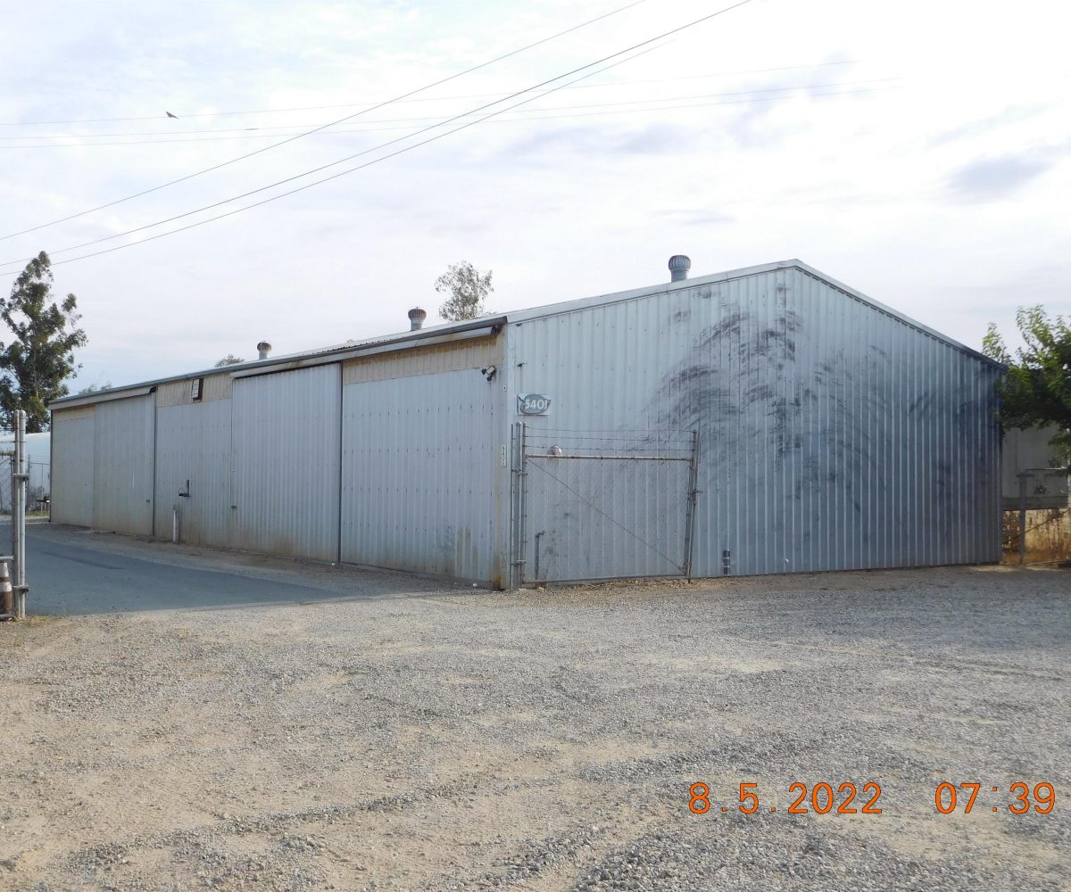 Non-residential wooden warehouse in countryside under clear blue sky