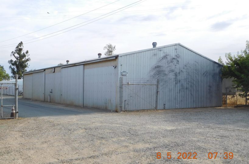 Non-residential wooden warehouse in countryside under clear blue sky