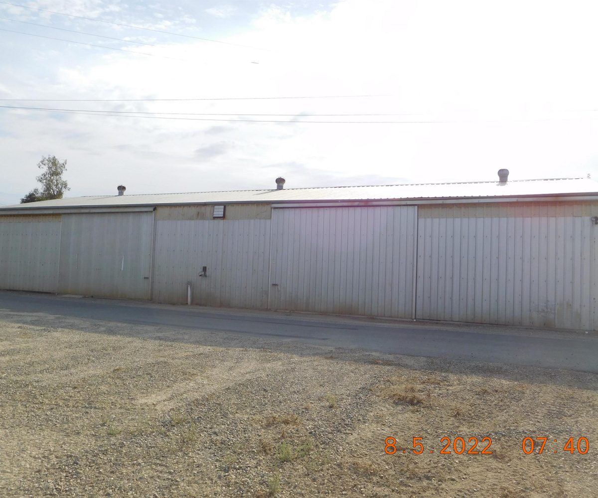 Non-residential wooden warehouse in countryside under clear blue sky