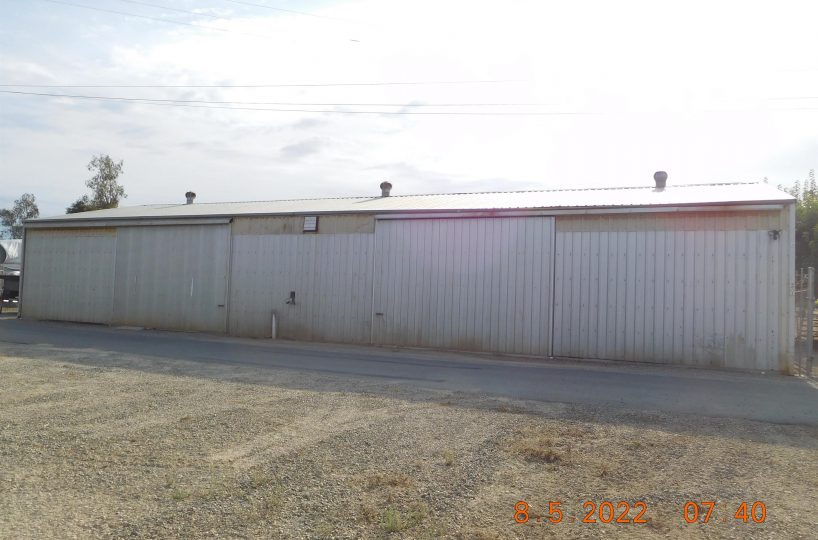 Non-residential wooden warehouse in countryside under clear blue sky