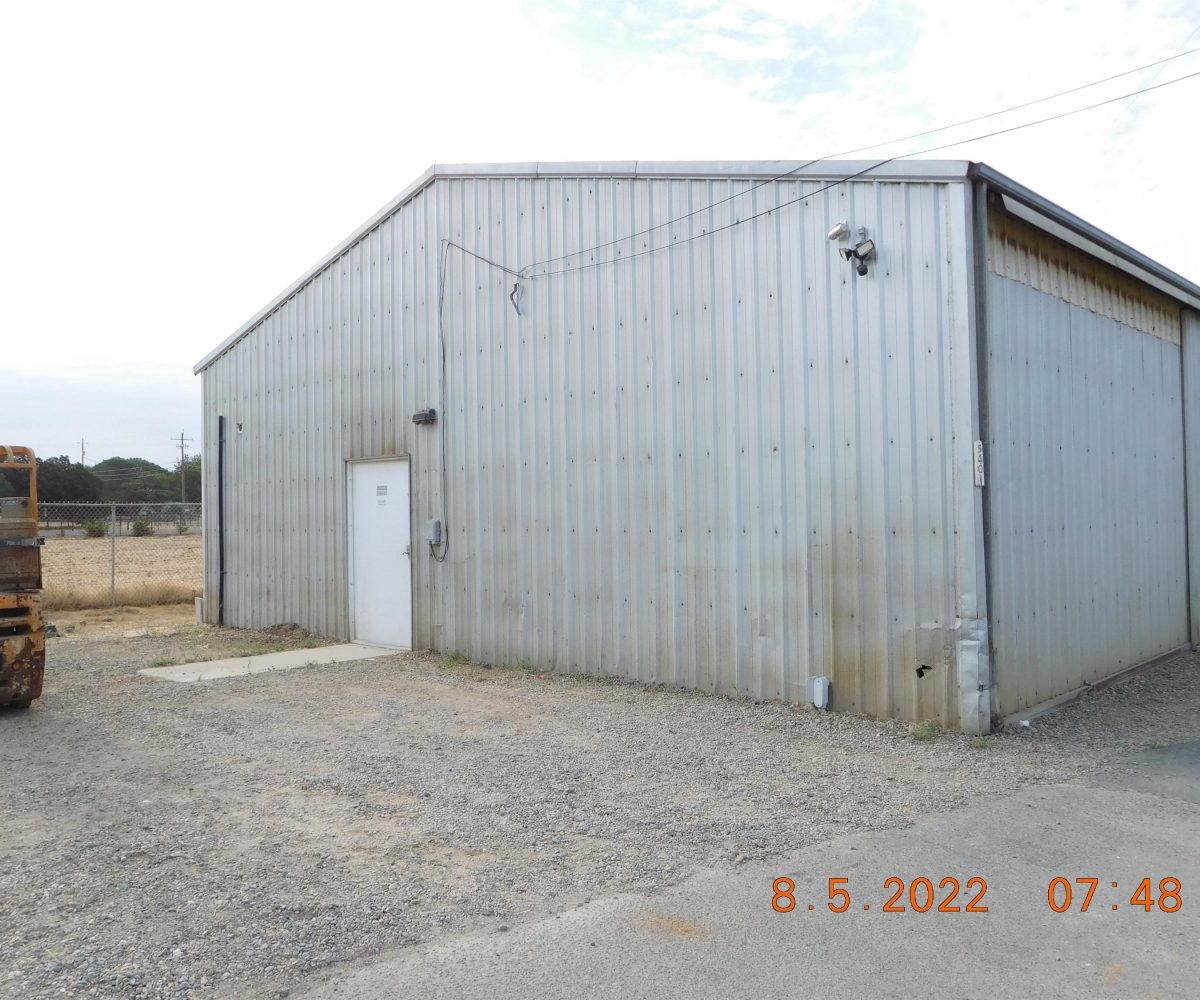 Non-residential wooden warehouse in countryside under clear blue sky